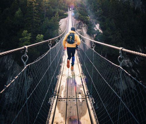 Woman walking across a rope bridge