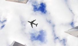 airplane flying over skyscrapers