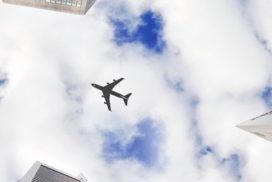 airplane flying over skyscrapers