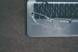 Glasses rest upon an open laptop