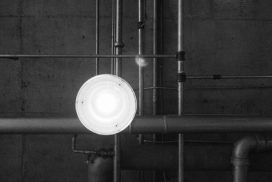 A black and white photo of a light in a pipeline.