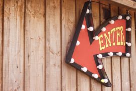 A sign that reads "Enter" hangs on a wood paneled wall.