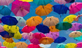 A bunch of colorful umbrellas flying in the air.