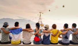 A group of people sitting on a syncthing pier looking at the ocean.