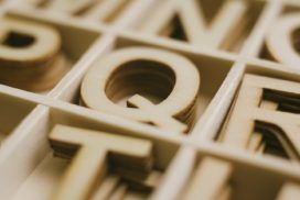 A close up of wooden letters in a box.