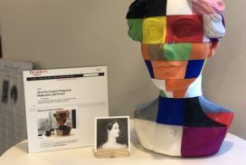 A sculpture of a woman's head with a book on it, representing the intersection of women and technology.