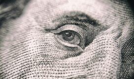 A close up of a man's eye on a dollar bill.