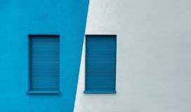 Two azure shutters on a wall.