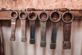 A collection of wrenches in varying sizes hanging on a wall.
