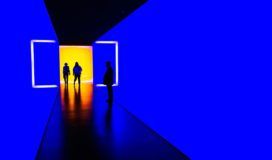 Two people from the UX team standing in a blue and yellow room.