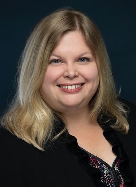 A smiling woman in a black jacket.