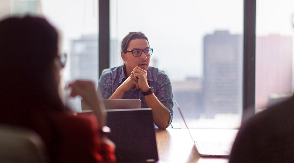 A group of people sitting around a table in a conference room.