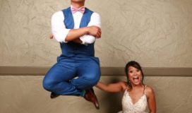 A young adult male in a blue suit vest appears to hover cross-legged in the air while a surprised young woman in a white dress looks on.
