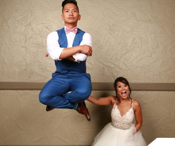 A young adult male in a blue suit vest appears to hover cross-legged in the air while a surprised young woman in a white dress looks on.