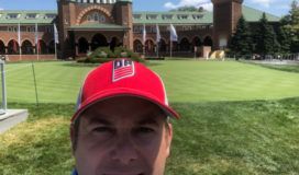 A man wearing a red hat in front of a building.