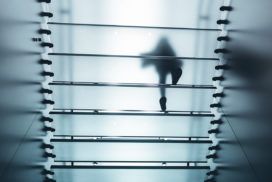 A person walking down a glass staircase.