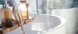 A bathroom with a wooden shelf for handmade soaps.