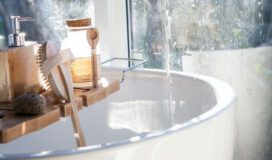 A bathroom with a wooden shelf for handmade soaps.