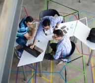 A group of people sitting around a data platform in an office.