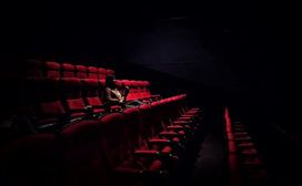 A person experiencing solitude in an empty cinema.