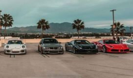 A group of sports cars parked in a parking lot.