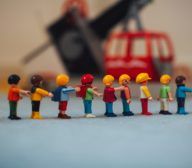 A group of UX design toy people standing next to a toy crane.