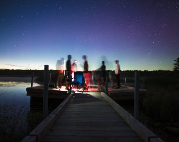 A group of people undergoing digital transformation, standing on a dock at night.