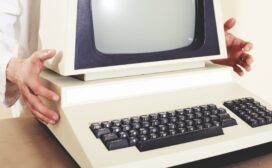 A man is holding a computer keyboard, showcasing the intersection of technology and history.