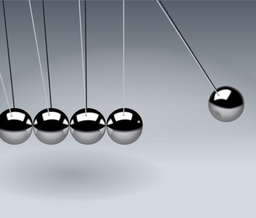 A set of metal balls hanging from strings in a modernized environment.