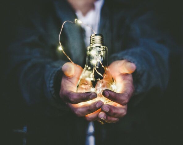 A person holding a digital transformation light bulb in their hands.