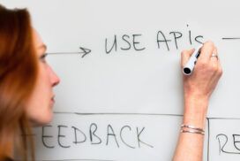 A woman writing on a whiteboard with the words API Integration.