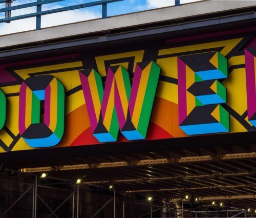 The word power is painted on the side of a bridge, showcasing its strong and impactful message.