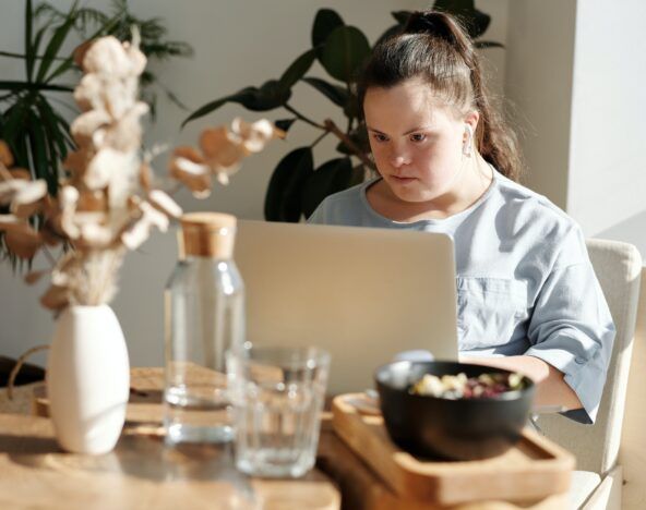 A woman using computer vision technology with a laptop at a table.