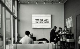 Inside a coffee shop, a sign reads "Fresh air, I miss you".