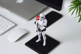 Stormtrooper figure on a desk next to a computer