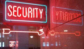 A red neon sign reading "SECURITY" with arrows, symbolizing enterprise AI security, is reflected on a marble wall. In the background, another neon sign reads "BAGGAGE DEPT.