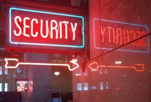 A red neon sign reading "SECURITY" with arrows, symbolizing enterprise AI security, is reflected on a marble wall. In the background, another neon sign reads "BAGGAGE DEPT.