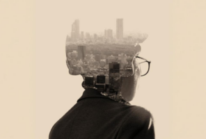 A person wearing glasses is seen from behind, with a cityscape superimposed within the silhouette of their head and shoulders.
